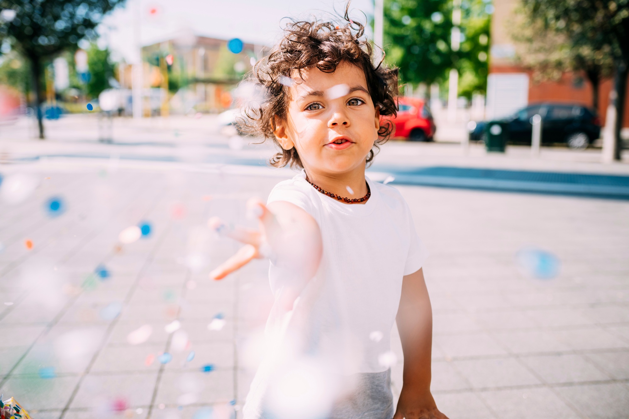 Toddler playing with confetti in park